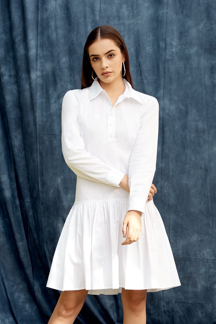 White drop waist shirt dress with pleated details and hemmed cuffs