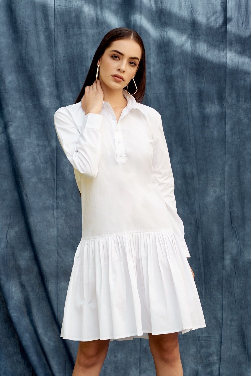 White drop waist shirt dress with pleated details and hemmed cuffs