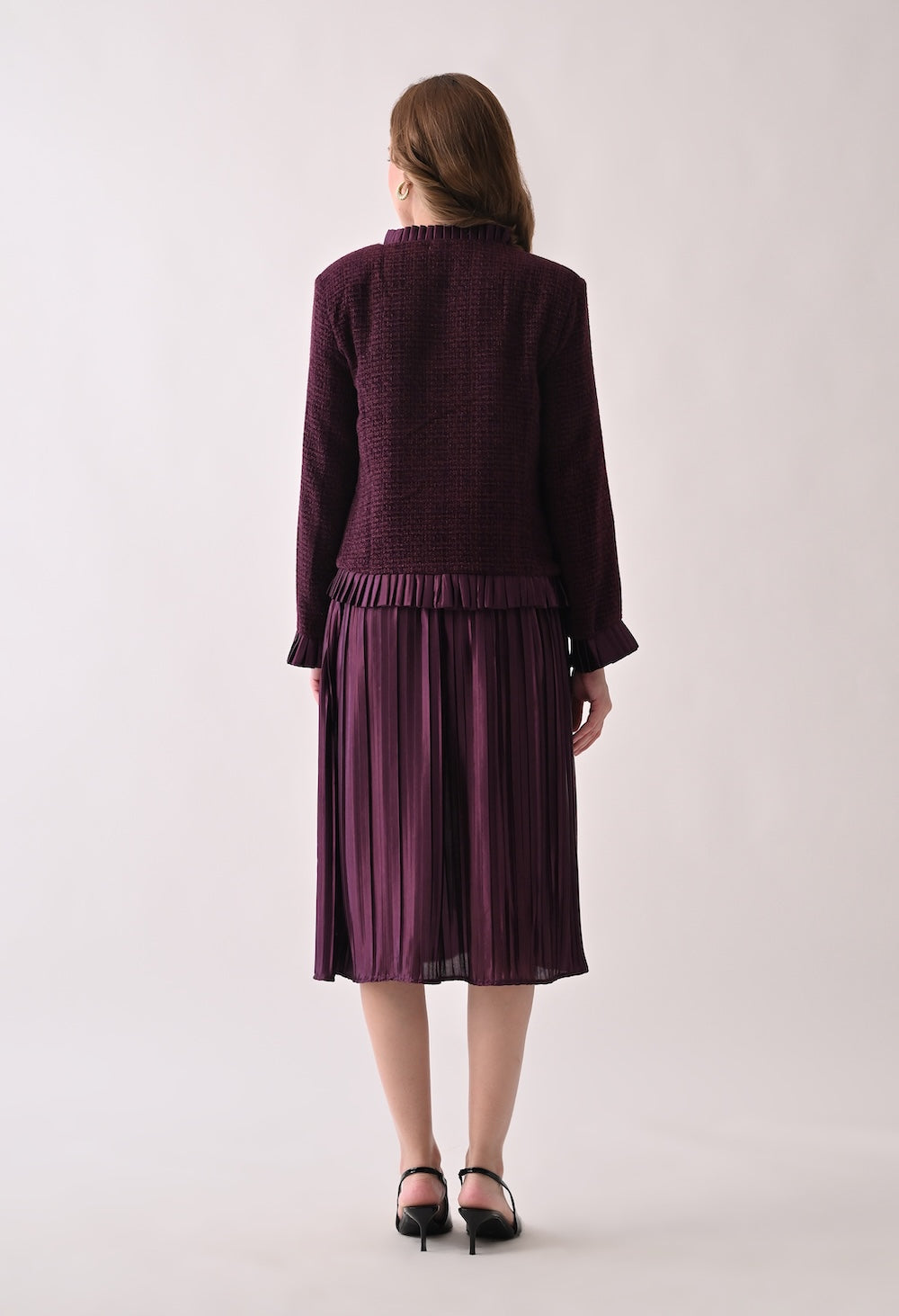 Wine colored tweed jacket with gold buttons and ruffle details paired with a matching pleated midi skirt