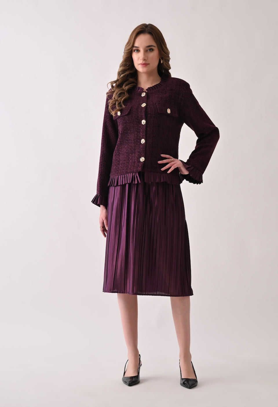 Wine colored tweed jacket with gold buttons and ruffle details paired with a matching pleated midi skirt
