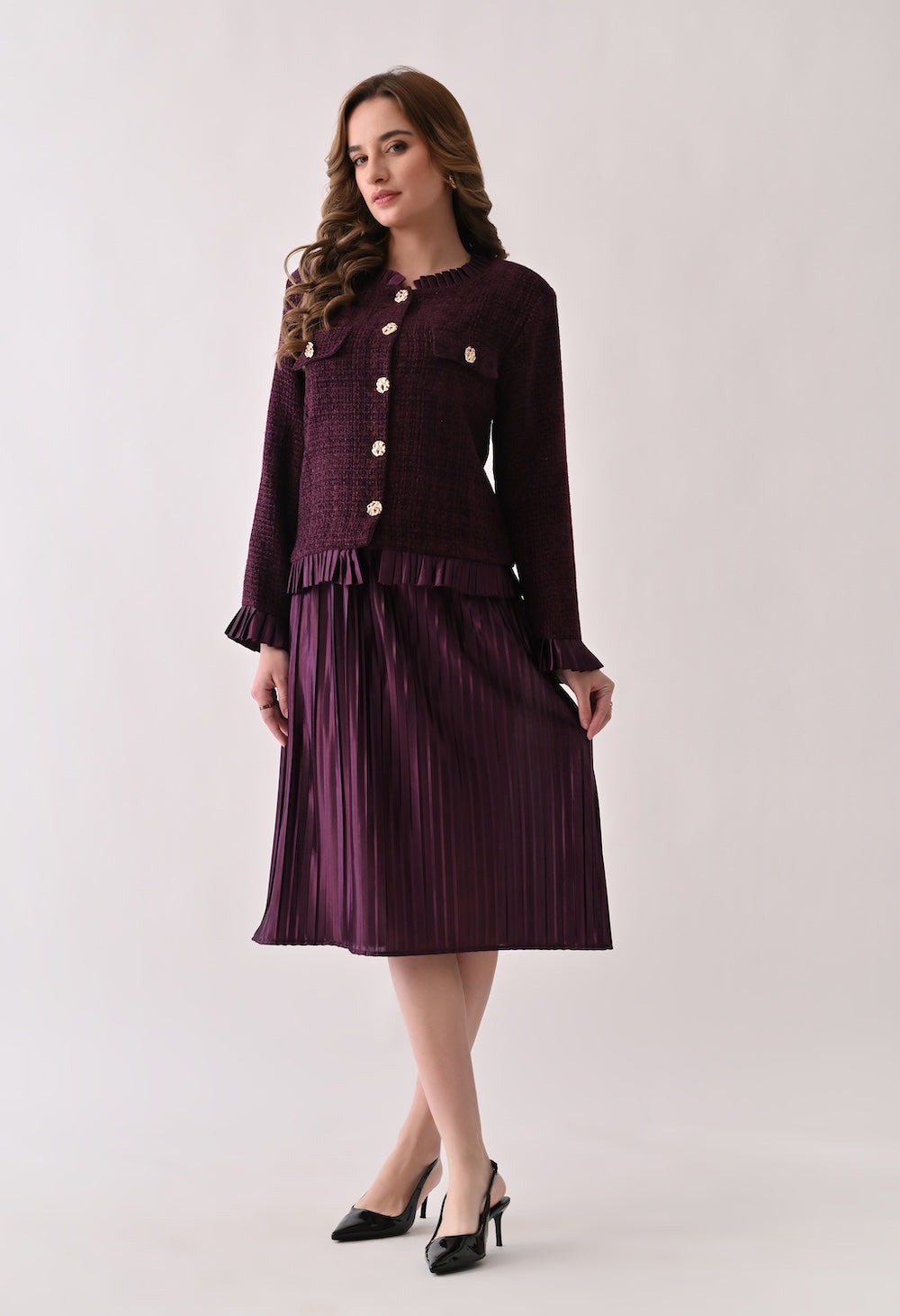 Wine colored tweed jacket with gold buttons and ruffle details paired with a matching pleated midi skirt