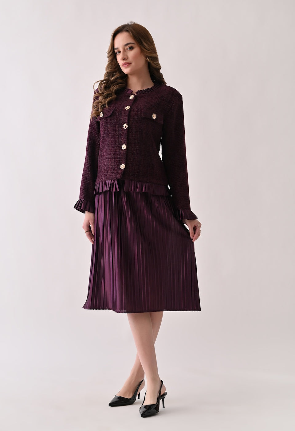 Wine colored tweed jacket with gold buttons and ruffle details paired with a matching pleated midi skirt