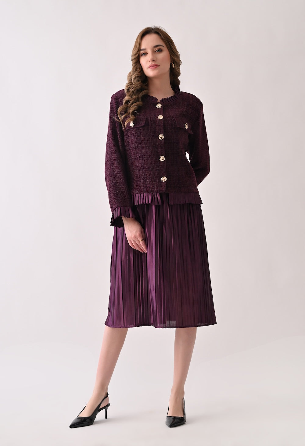 Wine colored tweed jacket with gold buttons and ruffle details paired with a matching pleated midi skirt