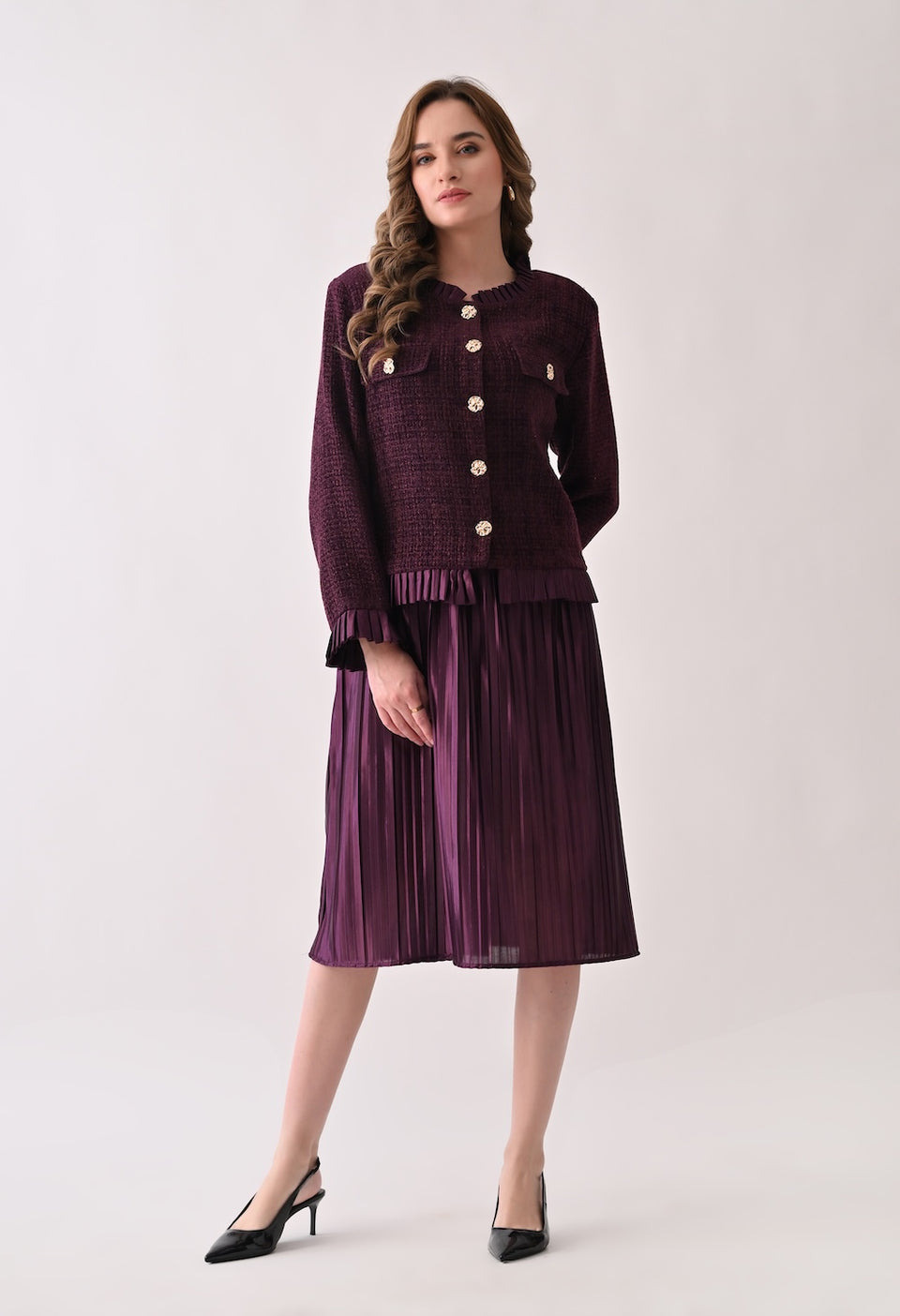 Wine colored tweed jacket with gold buttons and ruffle details paired with a matching pleated midi skirt